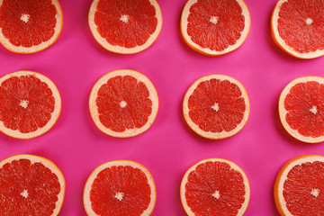 Flat lay composition with tasty ripe grapefruit slices on magenta background