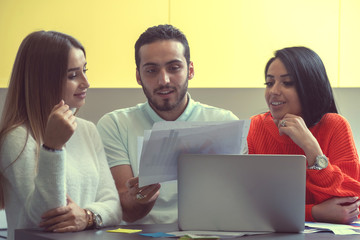 Business team at work. Group of young confident business people discussing project while spending time in the office