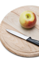 Apple and knife on wooden plate over white background
