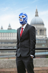 Young businessman wearing wrestling mask against St. Paul's Cathedral