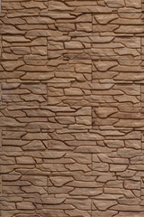 Decorative wall decoration with brick stone tiles, backdrop texture background. Wall in brown molded tile imitating masonry texture