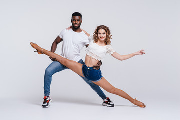 Couple dancers posing over white background. Man and woman are dancing, dance costumes. International dance group. Dancers dance. Passionate original variety of pair of dancers. Fitness concept