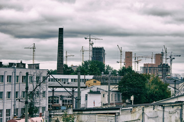 Gray cityscape-construction of new houses on the background of the industrial zone