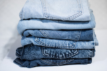 A pile of folded jeans in blue Background of clothing in indigo