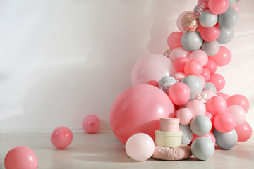 Beautiful composition with balloons near light wall
