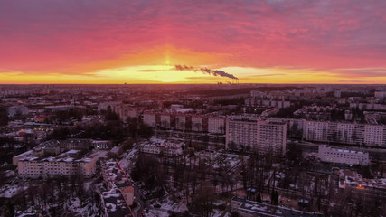 Beautiful pink sunset over the city. Smoke from the chimney on the horizon.