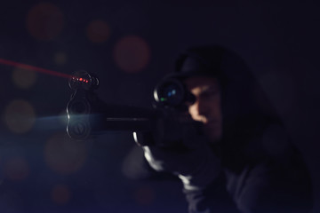 Professional killer on black background, focus on sniper rifle