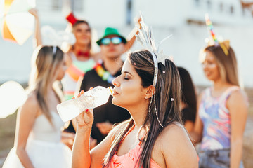 Brazilian Carnival. Woman in costume drinking water