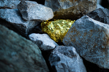 Gold nugget and grey granite stone background