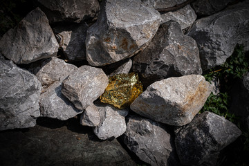 Gold nugget and grey granite stone background © Thicha