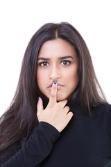 Naklejka premium Young woman with finger on her lips