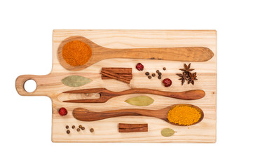 spices in wooden spoons on a wooden board. 
