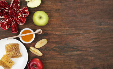 Flat lay composition with honey and fruits on wooden table, space for text. Rosh Hashanah holiday