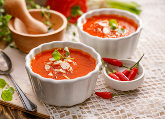 Cream soup of bell pepper  with the addition of almond flakes, chili peppers and fresh herb, close-up. A healthy and delicious vegan soup