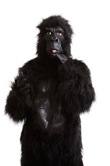 Young man in a gorilla costume sticking out his tongue against white background