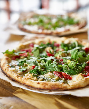 Fototapeta authentic oven fired pizza with pesto sauce and arugula
