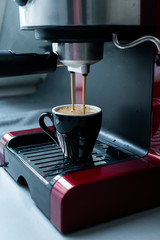 Delicious fresh espresso coffee cup on red espresso machine 