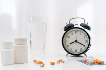 A bottle of water and capsules in white background	