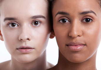 Portrait of two young female friends against white background