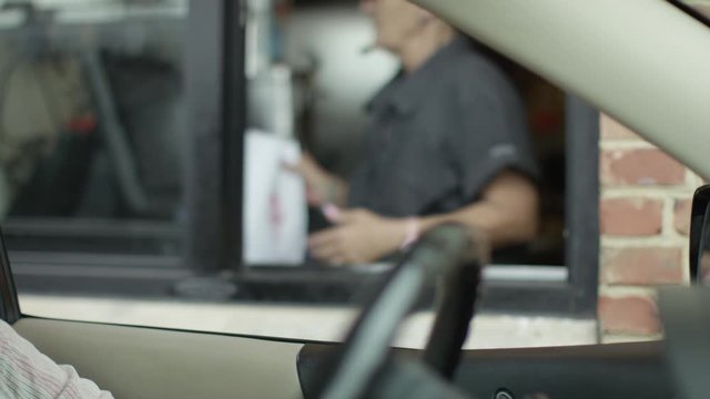 Woman In Drive-Thru Paying For Fast Food Meal