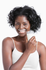 Portrait of happy young woman with milk moustache holding glass of milk