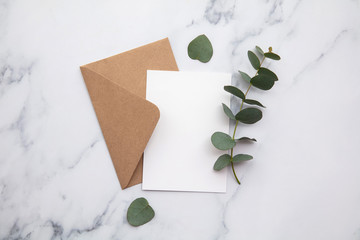 Blank white card and envelope with eucalyptus leaves. Blank invitation.