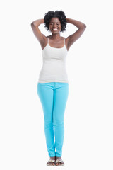 Frustrated young woman with hands behind head standing against white background