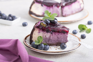 Slice of Blueberry flavour cheesecake swirled with blueberry sauce on a  biscuit crumb, bakery....