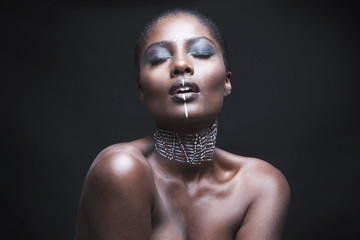 Sensuous young woman with painted face over black background