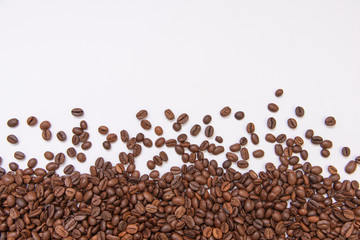fresh roasted coffee beans sprinkled on a white background