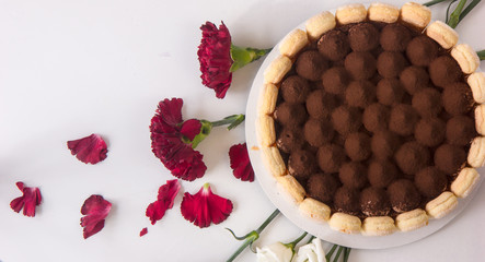 Round whole  Italian tiramisu dessert served on a plate. Fresh Birthday Cake. Isolated on white. Room for text. Clipping Path.  Valentines day, mothers day, womens day, wedding concept. Flat lay, top 