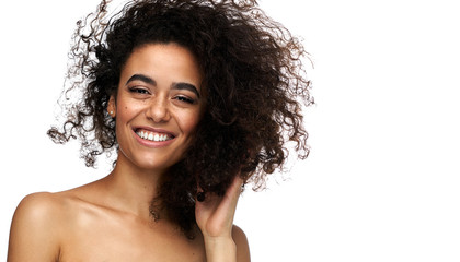 Portrait of beautiful cheerful latin american woman with afro hairstyle looking at camera, isolated...