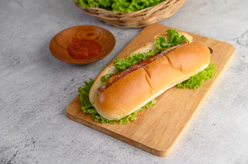 Hotdog with lettuce and tomato sauce on Wood cutting board  wood cutting board