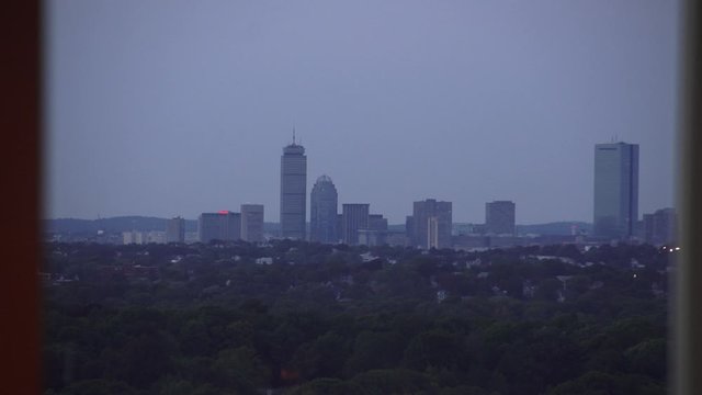 The Boston skyline as seen from a Quincy Massachusetts window as night falls.