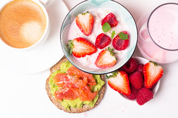 breakfast of cereal with berries, coffee and yogurt and toast