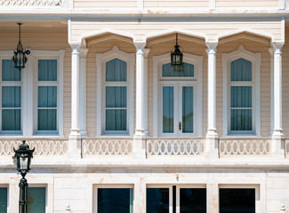 Wooden mansion close up detail. Beautiful classic architecture balcony with arch  columns and many windows.