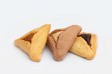 ozen haman, Jewish holiday pastry, for Purim holiday. Crispy dough stuffed with chocolate, halva or poppy flavored stuffing. Isolated on a white background