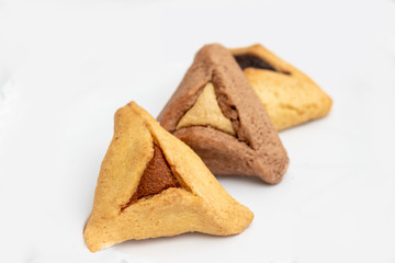 ozen haman, Jewish holiday pastry, for Purim holiday. Crispy dough stuffed with chocolate, halva or poppy flavored stuffing. Isolated on a white background