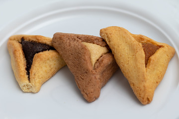 ozenei haman, Jewish holiday pastry, for Purim holiday. Crispy dough stuffed with chocolate, halva or poppy flavored stuffing. Isolated on a white background