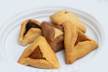 ozen haman, Jewish holiday pastry, for Purim holiday. Crispy dough stuffed with chocolate, halva or poppy flavored stuffing. Isolated on a white background