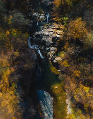 Aerial top down view of the Huk waterfall on the Pistynka River, surrounded by the Carpathian mountains. The beautiful nature. Sunny autumn day. Sheshory, Ukraine