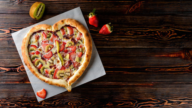 Heart-shaped Strawberry And Kiwi Pizza Cake On A Wooden Table