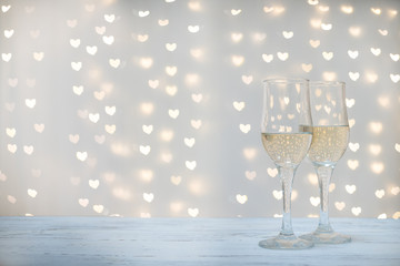 Champagne glasses on the background of festive lights bokeh heart Valentine's day, party
