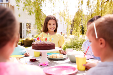 Girl Celebrating Birthday With Friends Having Party In Garden At Home