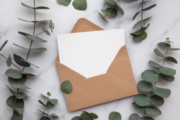 Blank white card and envelope with eucalyptus leaves. Blank invitation.