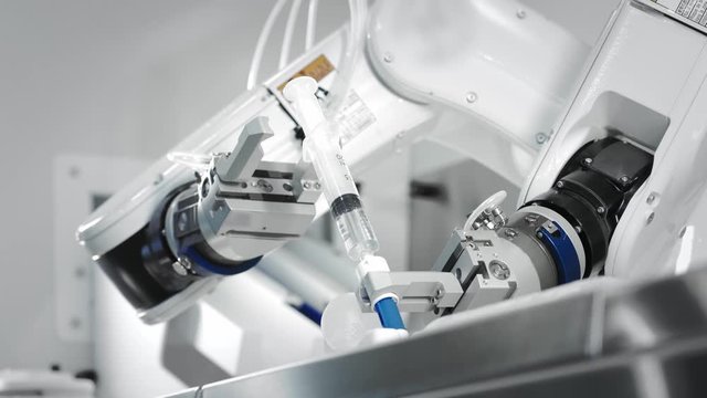 The innovative arms of a robotic arm make an injection of chemotherapy for a cancer patient. New technologies in medicine. Two manipulators draw medicine into a syringe. Hazardous substance injected.
