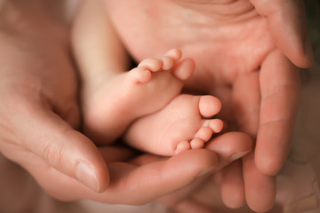 Heels of a newborn baby in the hands of a man - 316762701