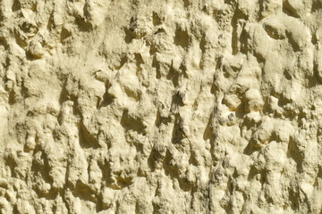 Gelbliche grobe Steintextur, Hausmauer, Schatten