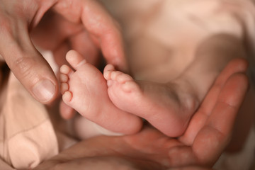 Heels of a newborn baby in the hands of a man - 316762744