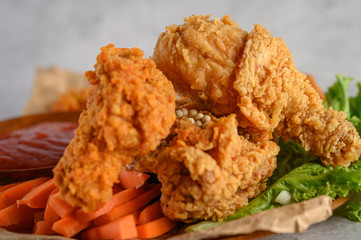 Crispy fried chicken on a plate with tomato sauce and carrot, Selective focus.
